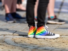legs of young man in a sneakers with rainbow symbol of lgbt