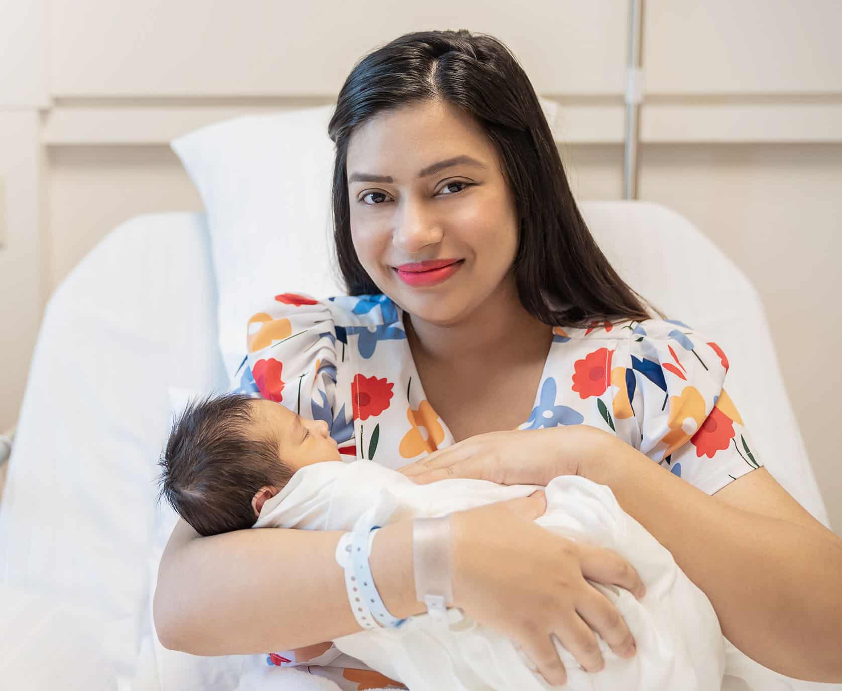 closeup portrait of young asian indian hispanic mother day holding newborn baby with copy space. healthcare and medical daycare nursery love lifestyle together single mom motherâs day holiday concept