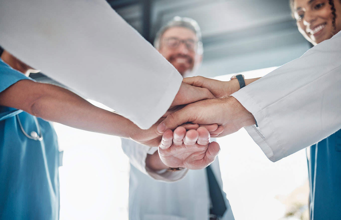 doctor, team and hands together in healthcare agreement, trust or partnership for success or unity at clinic. group of medical experts piling hand in teamwork collaboration, achievement or goals